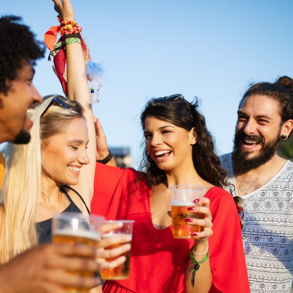 Happy young group of people attending festivals at summer, having fun together